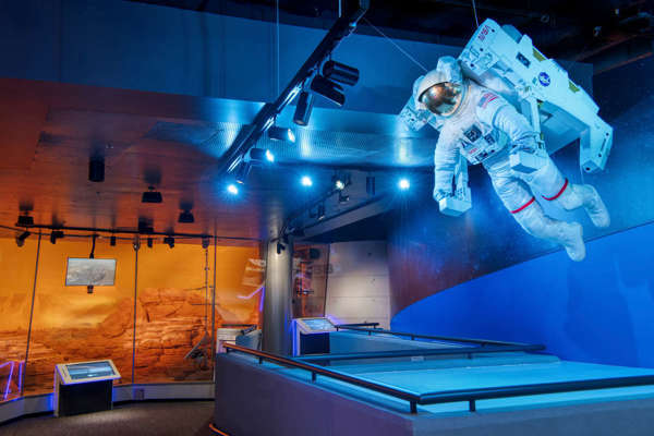 An astronaut figure in the foreground with the Mars Outpost in the background