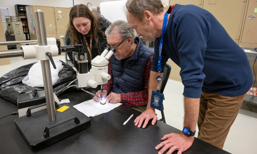 From left to right, report authors Dr. Gussie Maccracken, Dr. David Krause and Dr. Patrick O'Connor study the dinosaur fossil at the Denver Museum of Nature & Science.
