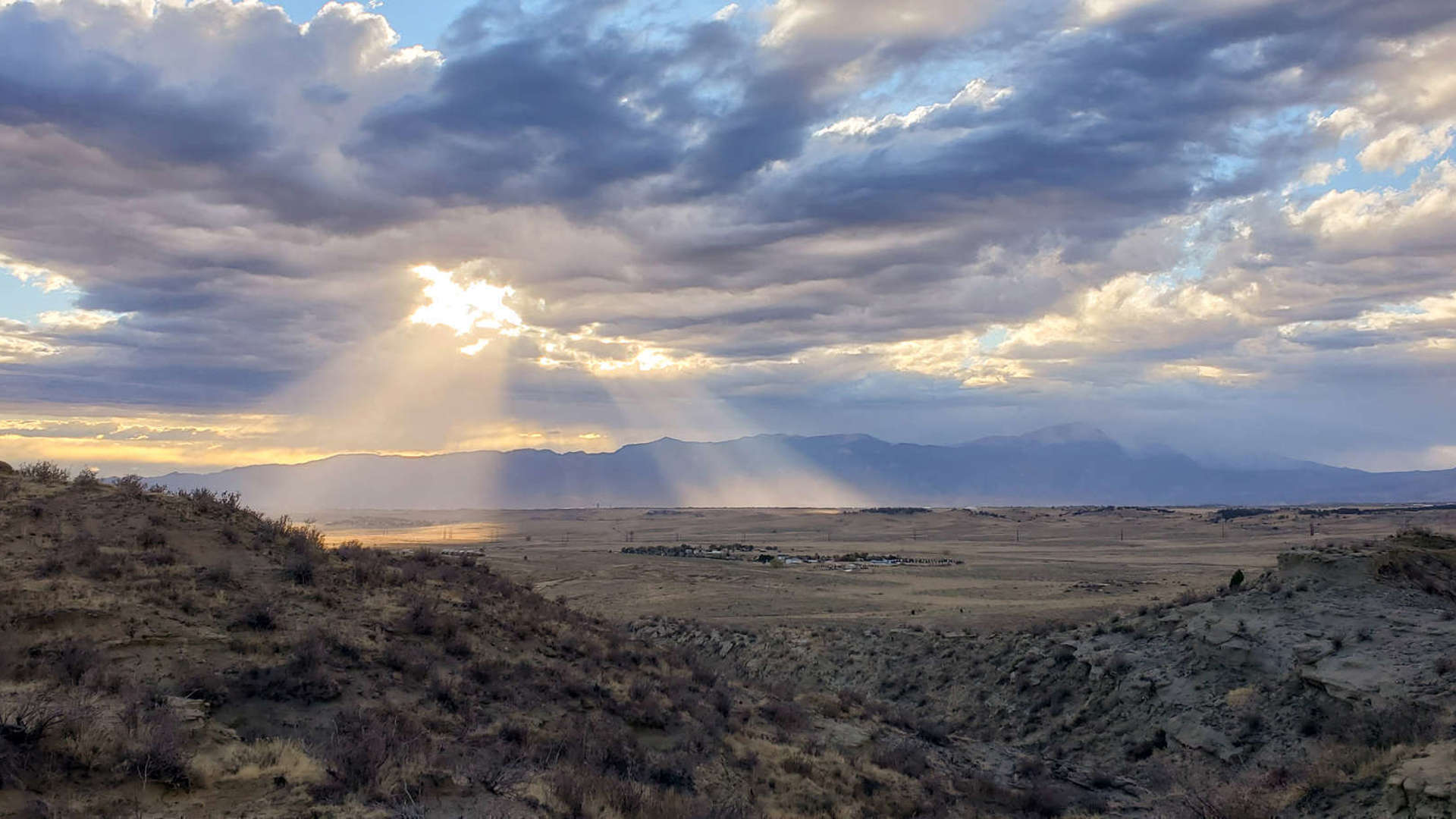 Panaromic view of a partly cloudy sky with sun beaming through, from Corral Bluffs looking west.